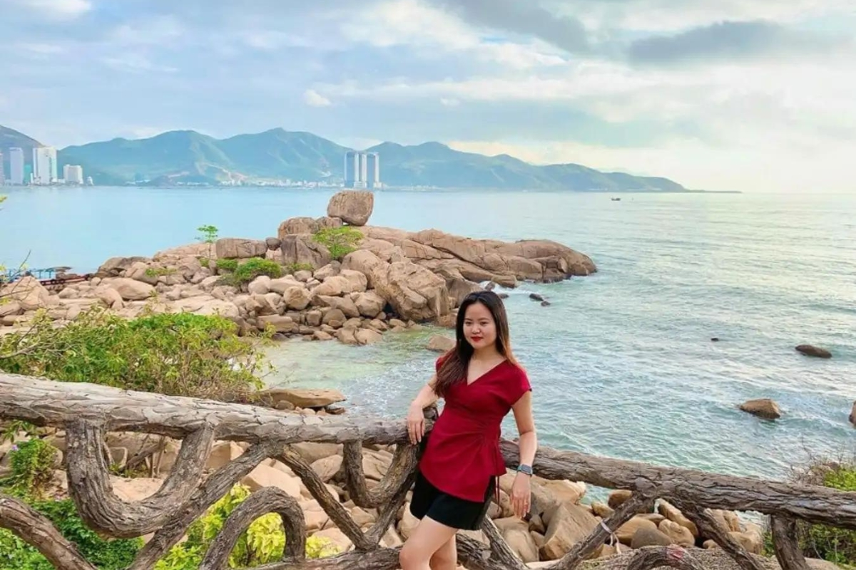 Tourists exploring Hon Chong Beach with clear blue water and rocky landscape